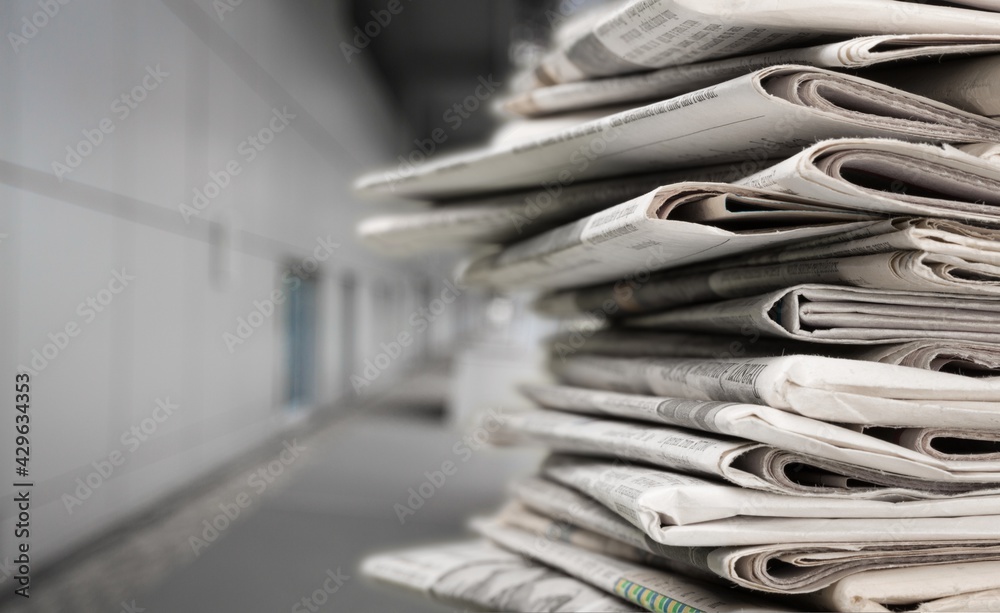 Pile of newspapers stacks on blur background Pile of newspapers stacks on blur background