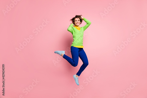 Full size photo of young active girl happy positive smile have fun crazy jump up isolated over pastel color background