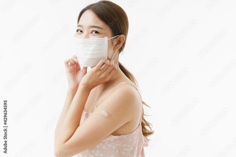 Young Asian woman in the casual dress wearing protective facemask after getting Covid-19 vaccinated, concept vaccination campaign. Comfortable breathe while without face mask.Smile with white teeth. Young Asian woman in the casual dress wearing protective facemask after getting Covid-19 vaccinated, concept vaccination campaign. Comfortable breathe while without face mask.Smile with white teeth.