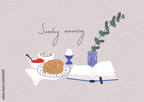 Lazy Sunday breakfast with a book, a croissant with jam, a boiled egg and a cup of coffee, still life