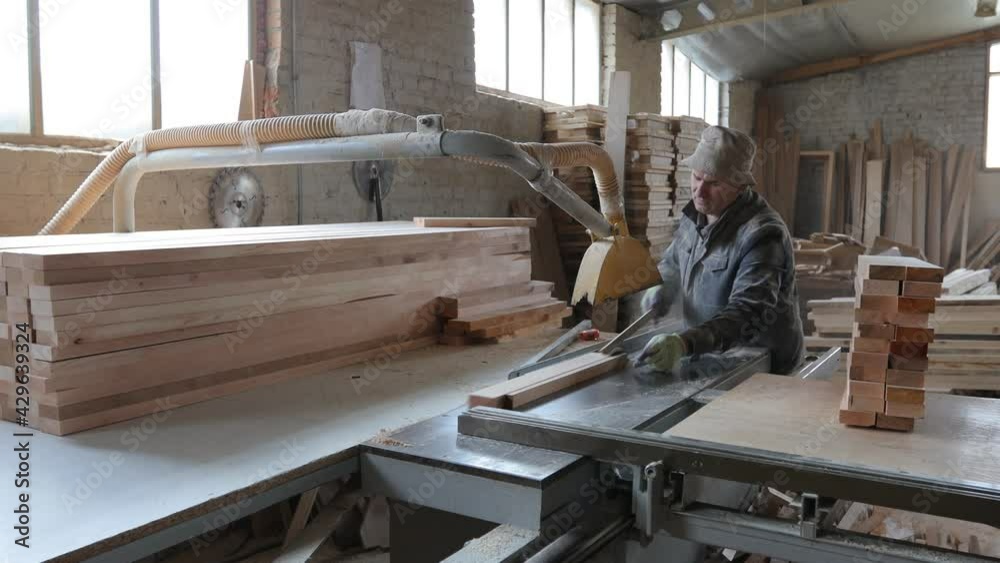 Carpenter working in his own woodshop. He is working with sawmill. Small business concept Carpenter working in his own woodshop. He is working with sawmill. Small business concept