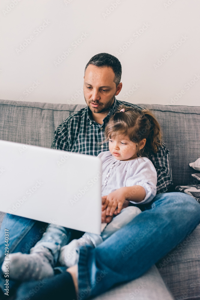 Fototapeta premium Dad and daughter at home using computer