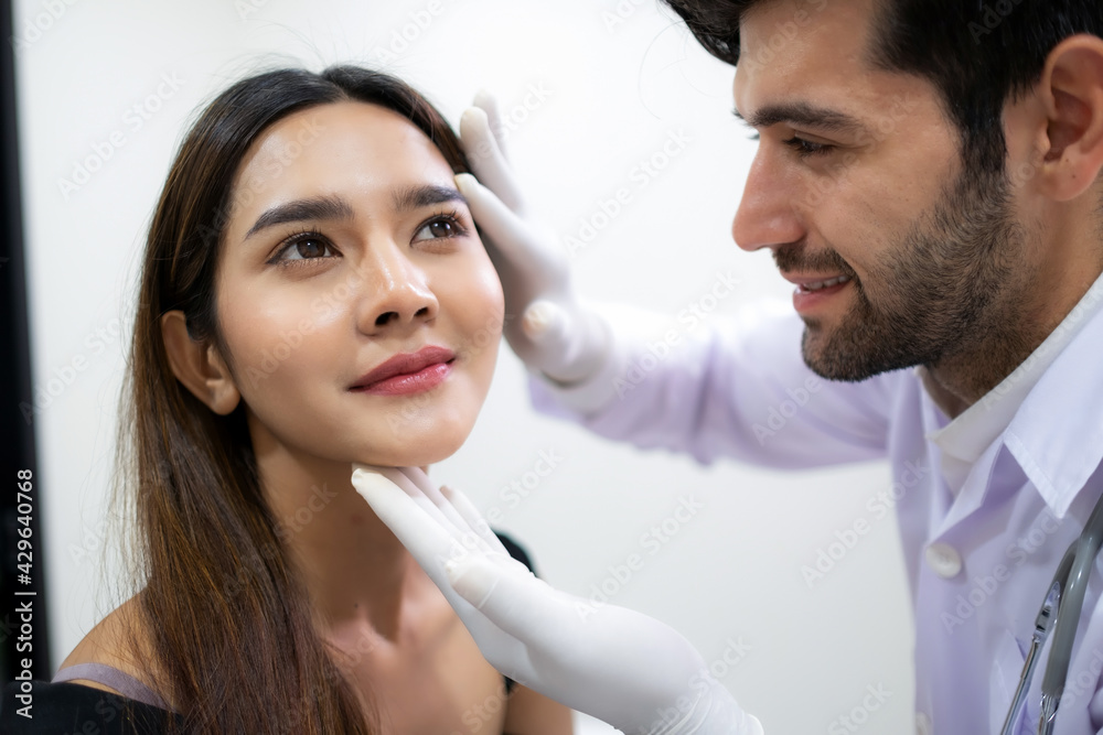 Beautiful woman check skin and face with doctor before plastic surgery in the clinic. Beautician touching and looking at woman face. Surgery and high resolution, beauty treatment concept Beautiful woman check skin and face with doctor before plastic surgery in the clinic. Beautician touching and looking at woman face. Surgery and high resolution, beauty treatment concept