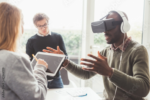 Three millennials multiethnic businesspeople using 3D viewer