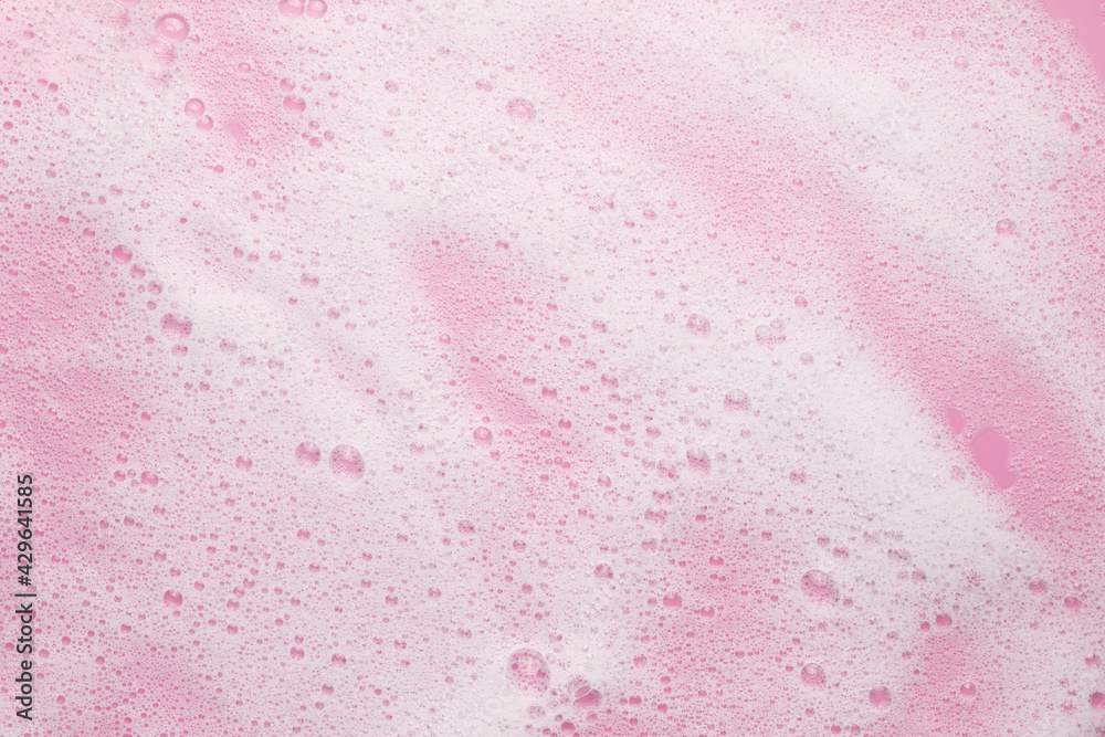 White airy foaming cosmetic liquid on a pink background. Bath foam, mousse, shampoo. Beauty or skin care concept. White airy foaming cosmetic liquid on a pink background. Bath foam, mousse, shampoo. Beauty or skin care concept.
