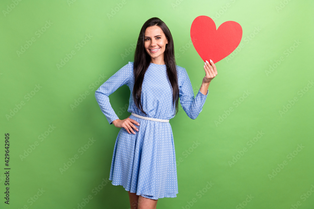 Photo of sweet optimistic brown hair lady show heart wear blue dress isolated on green color background Photo of sweet optimistic brown hair lady show heart wear blue dress isolated on green color background