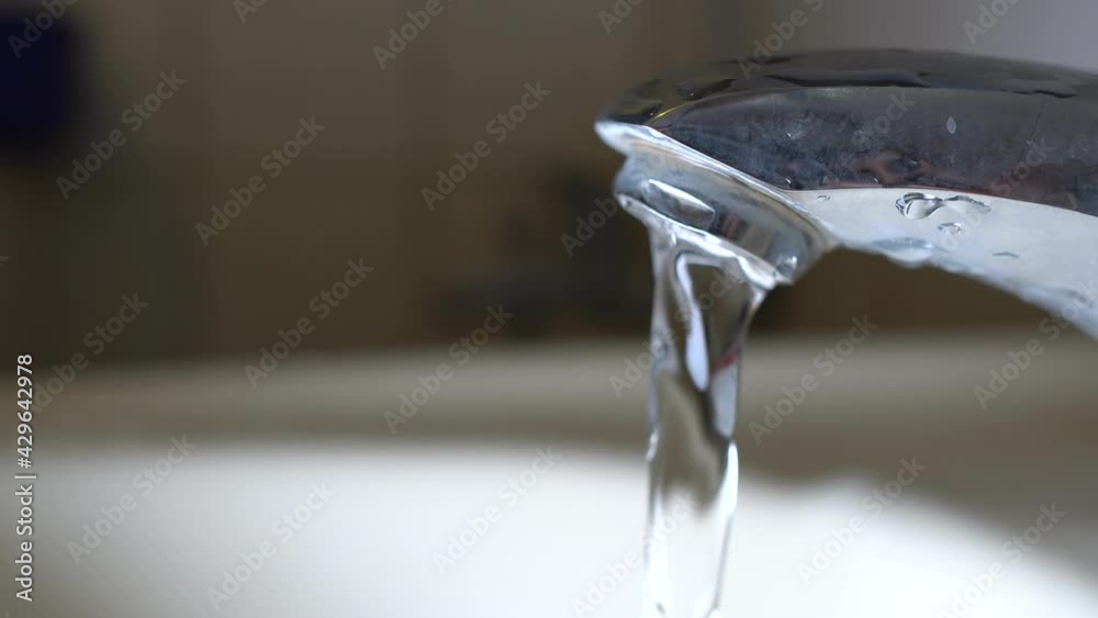 Faucet and sink. Water flows from the tap. The subject is on the right. Faucet and sink. Water flows from the tap. The subject is on the right.