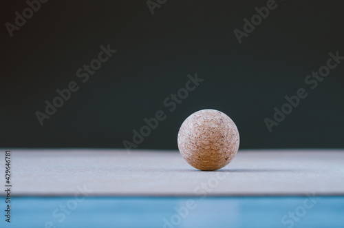 Cork massage ball for fascia on a cork yoga mat, on a black background. Concept: eco friendly and biodegradable props for self care at home
