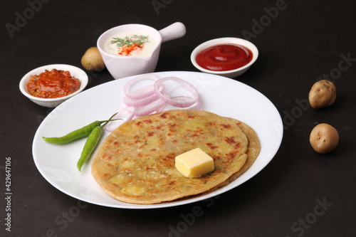 Traditional Indian food Aloo paratha or potato stuffed flat bread. served with pickle  tomato ketchup and curd  butter  onion  chili.