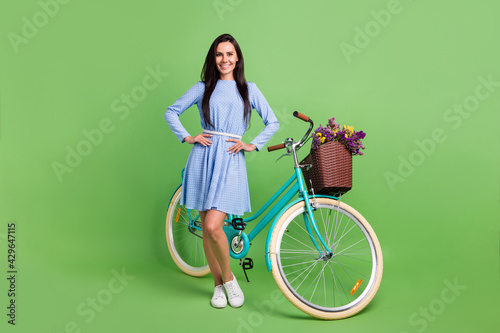 Full body photo of cute trend brown hair lady near bicycle wear dress isolated on green background © deagreez