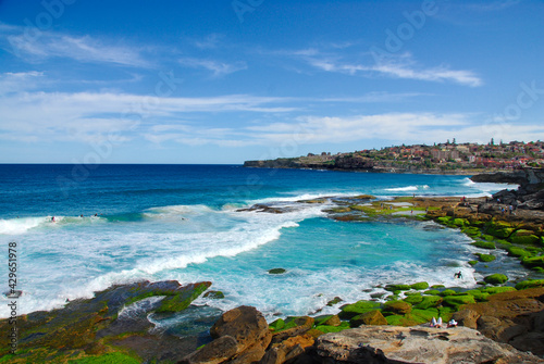 Surfers and swimmers enjoying a beautiful summer day at Tamarama and Bronte beaches in New South Wales, Australia.