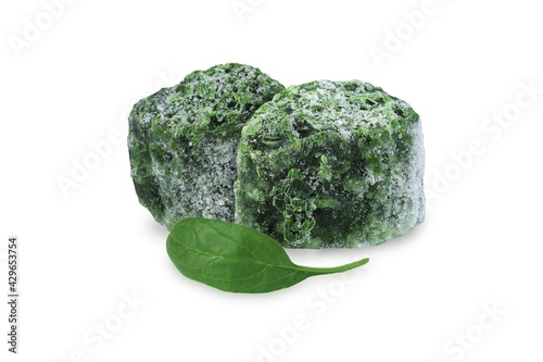 Fresh spinach leaf and frozen spinach cubes on an isolated white background.