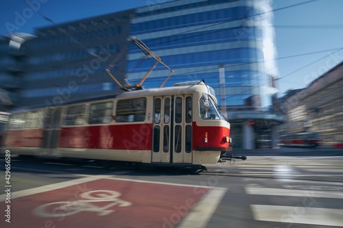 Tram of public transportation in blurred motion against crossroad. Daily life in city. Prague, Czech Republic.