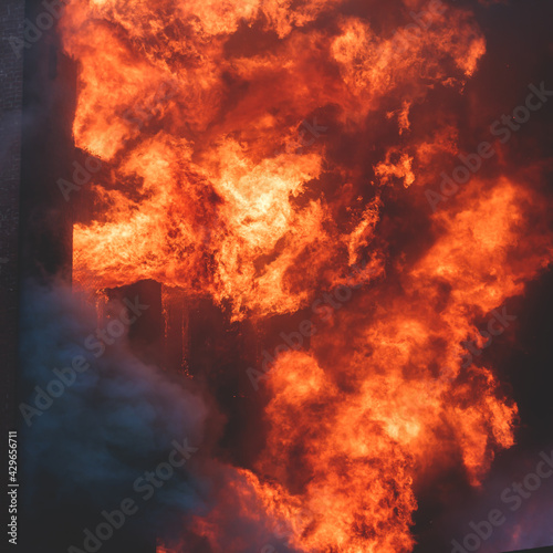 Massive large blaze fire in the city, brick factory building on fire, hell major fire explosion flame blast,  with firefighters team firemen on duty, arson, burning house damage destruction © tsuguliev