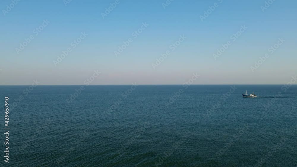 Aerial wide shot of Ship cruising on endless Ocean during beautiful blue sky and sunlight. High angle view. Aerial wide shot of Ship cruising on endless Ocean during beautiful blue sky and sunlight. High angle view.