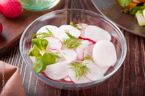 Spring fresh salad with radish and basil on the dinner table