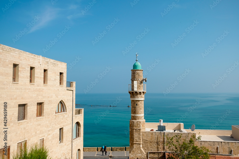View of the St. Peter`s Church, bell tower of the Saint Peter Church and the al-Bahr Mosque or Sea Mosque in Old Jaffa, Tel Aviv Yaffo, Israel.