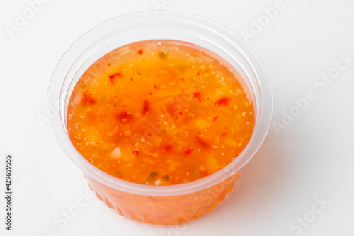 A cup of sweet and sour sauce on white background