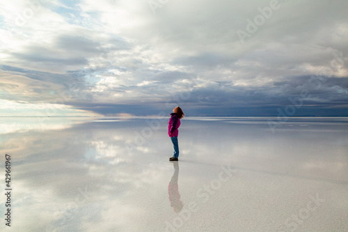 a woman walking on the reflection of the sunrise