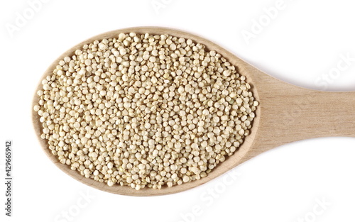 Organic quinoa seeds in wooden spoon isolated on white background, top view