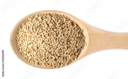 Organic integral sesame seeds in wooden spoon isolated on white background, top view