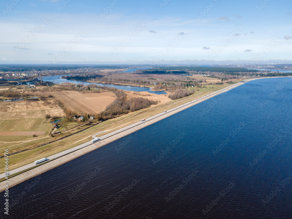 Aerial view of the huge dam in Latvia near city of Salaspils and Riga. A huge reservoir of water in river Daugava and road