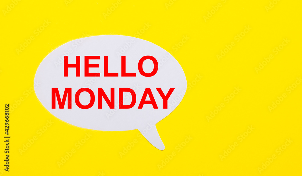 On a bright yellow background, white paper with the words HELLO MONDAY On a bright yellow background, white paper with the words HELLO MONDAY