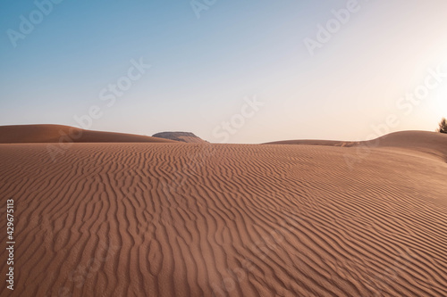 Sunset in Dubai desert sand waves and dunes.