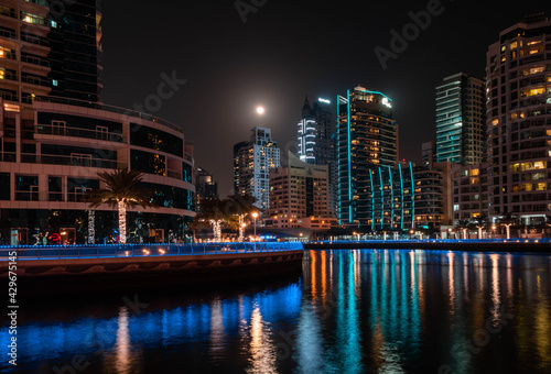 Dubai Marina District in Dubai. High buildings is reflecting in the water in the night illumination. Dubai, UAE. 