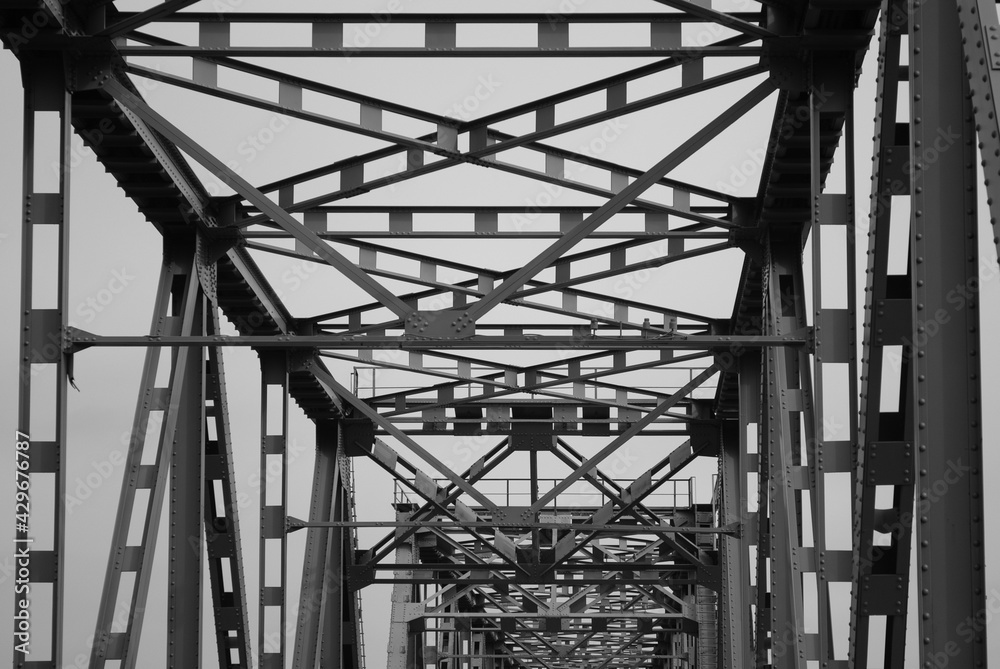 metal structure of a road bridge against a gray sky metal structure of a road bridge against a gray sky
