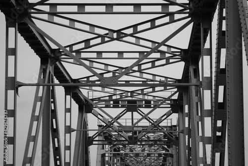 metal structure of a road bridge against a gray sky