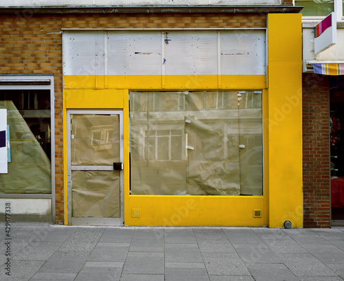 Fotografie closed and locked yellow pawnshop, impact of the corona pandemic 2021 in Germany during lockdown, closed small business