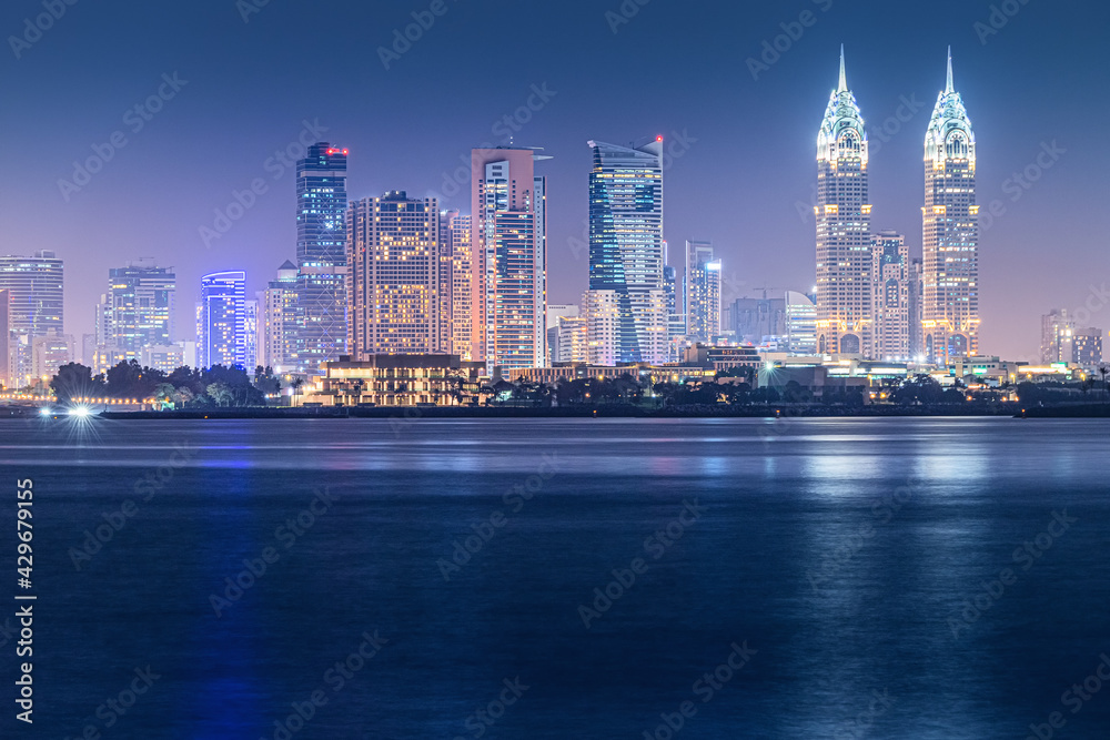 Obraz premium Night sea view of the brightly lit Internet City area in Dubai. Concept of real estate investment and the cost of electricity for lighting