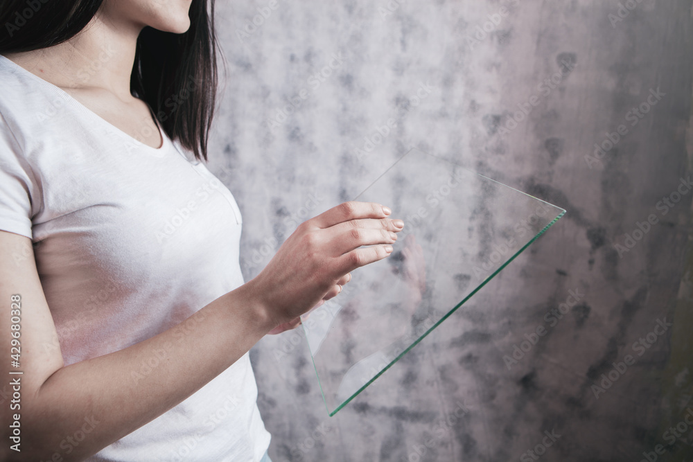 a girl's hand holds a glass touch screen