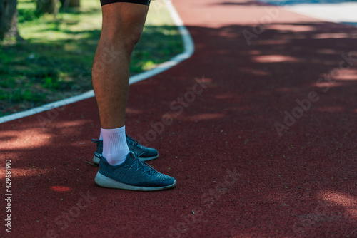 Close-up photo of male running shoes on a race track in the park