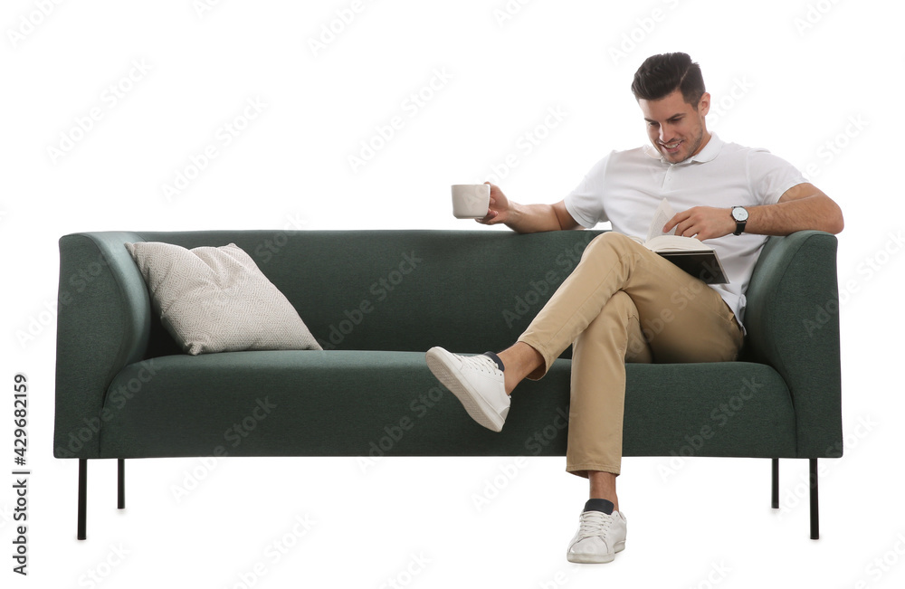 Man with cup of drink and book on comfortable green sofa against white background Man with cup of drink and book on comfortable green sofa against white background