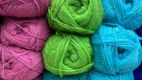 Blue, green and pink of wool yarn. Multicolored skeins of wool close-up