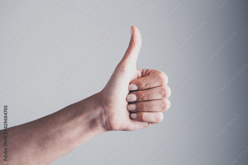 Close up image of young woman making and showing ok hand sign