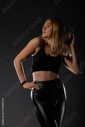 Sexy blonde in leather black pants going crazy. © qunica.com