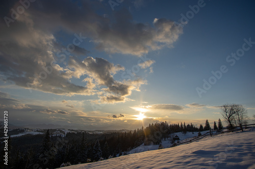 Panorama of a village in winter in the mountains at sunset