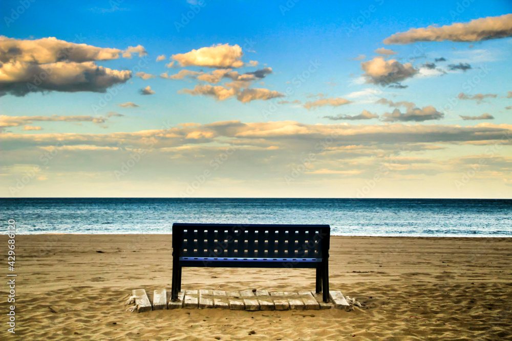 Bench on the beach of Alicante at sunset