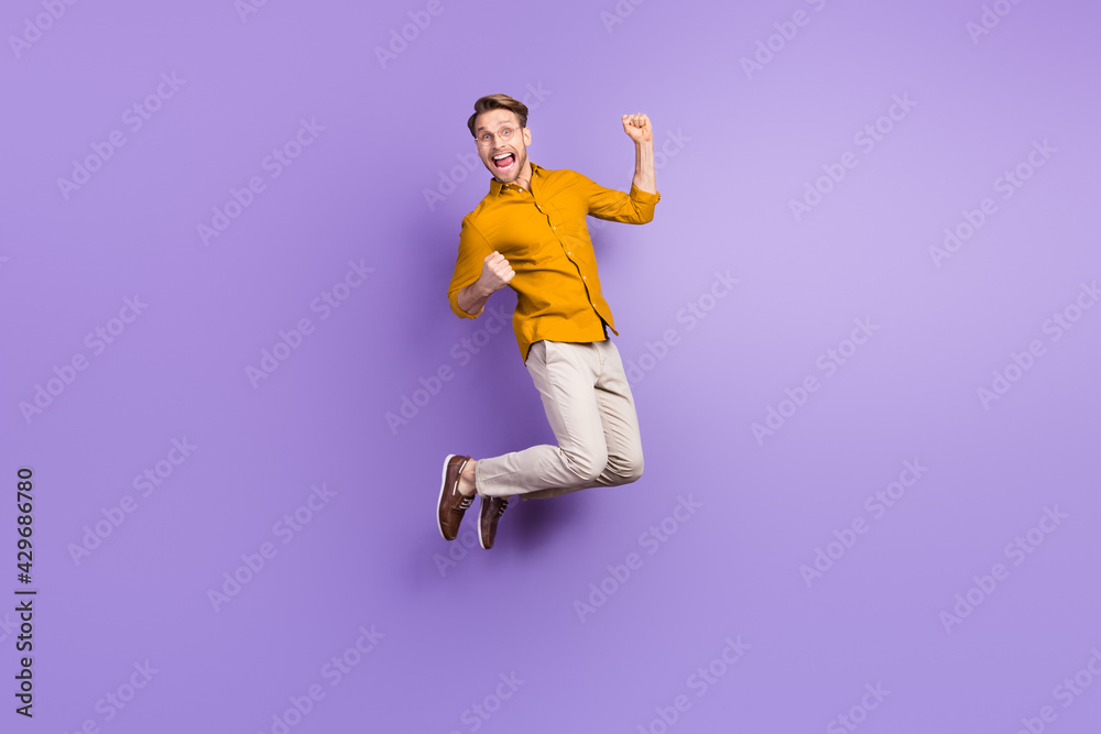 Full length body size photo of businessman jumping up gesturing like winner isolated on vibrant violet color background