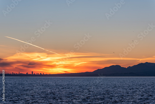 Sunset in the city of Benidorm  with a bluish sea.
