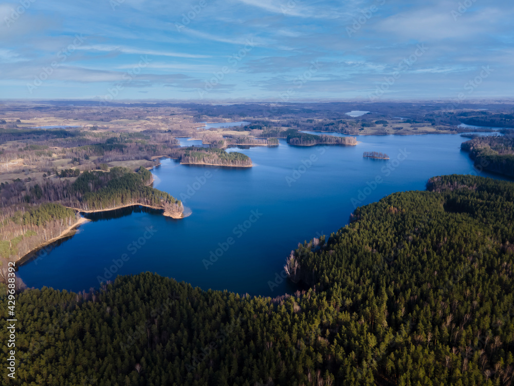 Aerial view of forest and lake with blue water. Landscape of Latvia