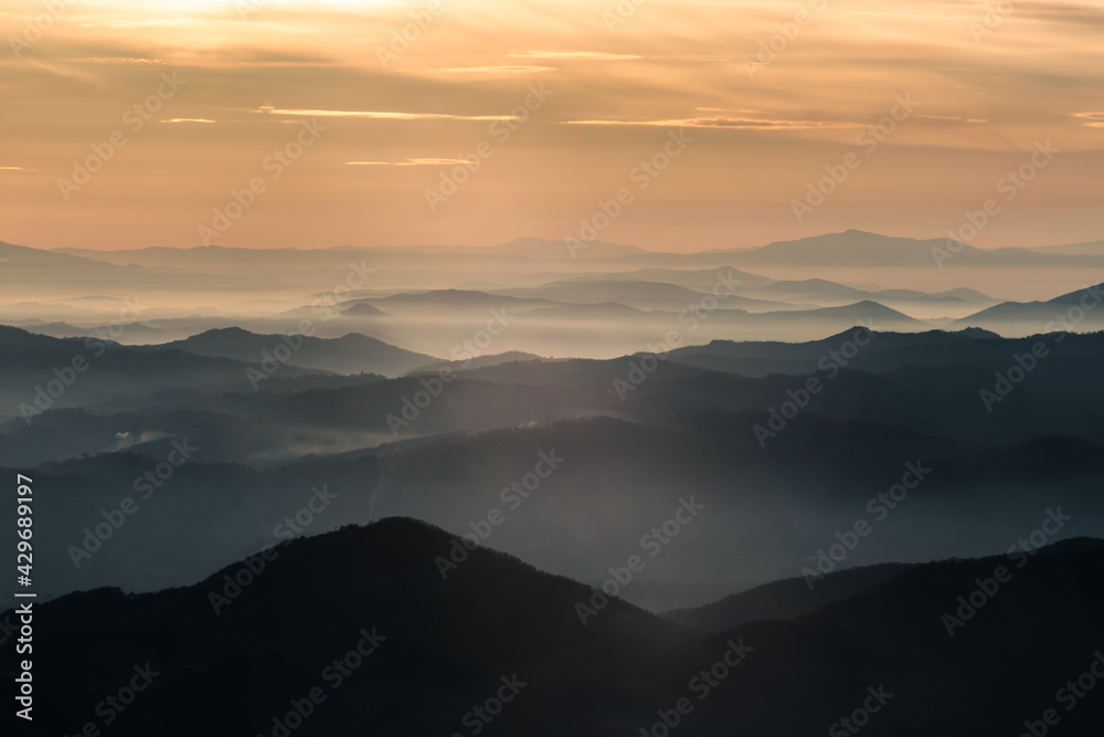 Mist and fog between valley and layers of mountains and hills at sunset, in Umbria Italy Mist and fog between valley and layers of mountains and hills at sunset, in Umbria Italy
