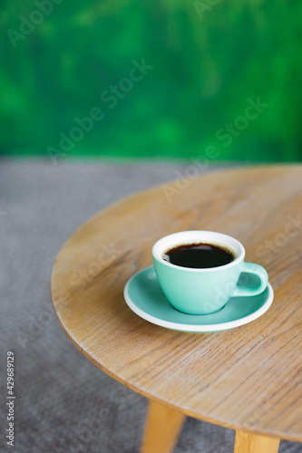 coffee in a mint-colored cup on a wooden table  start the day or lunch with partners in a coffee shop  meet with friends or coffee alone  enjoy the taste of black coffee Americano or cappuccino