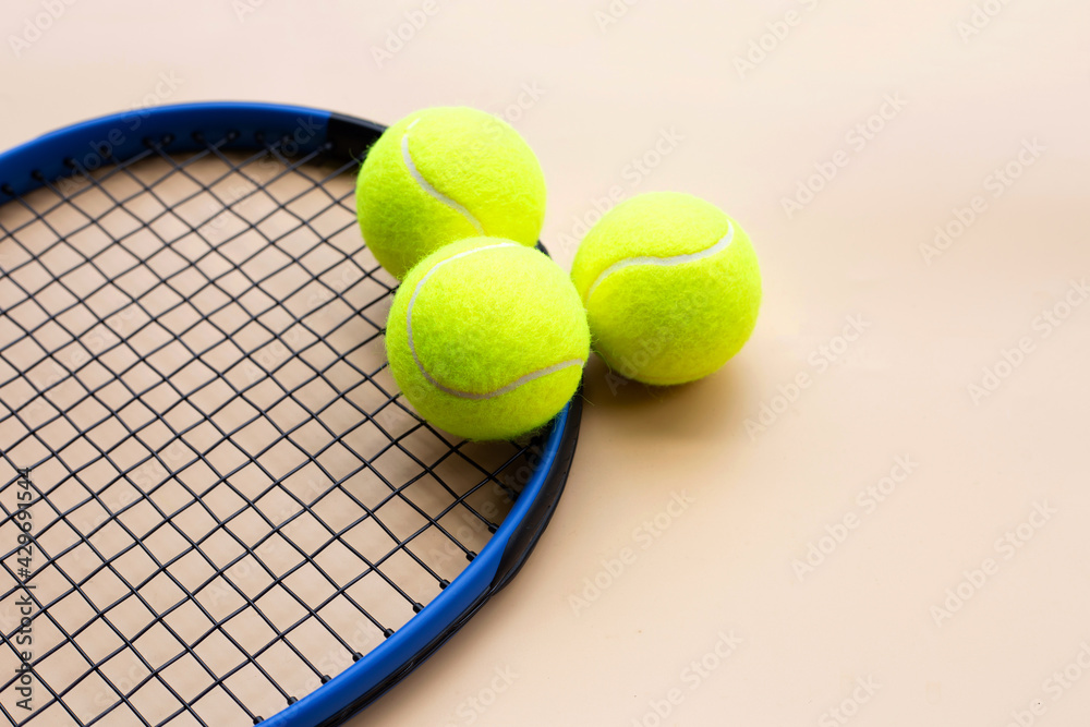 Tennis racket with balls on yellow background.