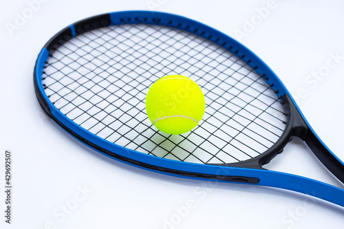Tennis racket with ball on white.