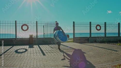 Shot of man go to water with surfboard. Male surfer on sunny day at the beach laughing and smiling, happy to be outside and do physical activity to stay healthy and fit. 4K