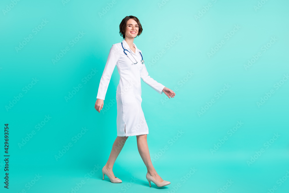 Fotka „Full length body size side profile photo female doctor walking  forward wearing white uniform isolated vivid teal color background“ ze  služby Stock | Adobe Stock